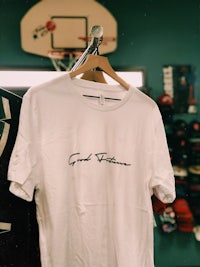 a white t - shirt hanging on a rack in a store
