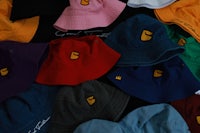 a group of colorful bucket hats laying on top of each other